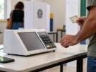Urna eletrônica diante de mapa do Brasil em ambiente de apuração das Eleições 2026